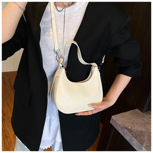Detail of minimalist cream woven hobo bag with adjustable strap and silver zipper