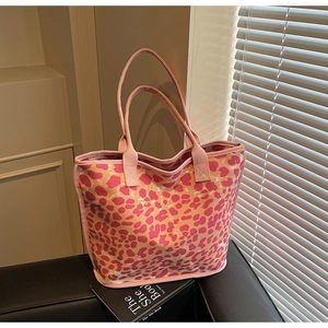 Detail shot of large canvas tote bag featuring vibrant pink and orange animal print texture