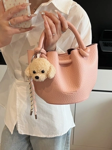 Pink lychee grain bucket bag with cute poodle plush charm and braided strap
