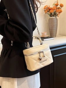 Quilted cream crossbody bag with gold heart pendant and metal chain strap for women