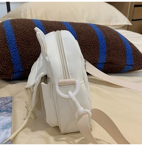 Dettaglio laterale della borsa a tracolla bianca in nylon con orecchie e cinturino