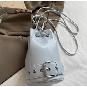 Détail de vue de dessus du sac seau bleu clair avec cordon et boucle argentée décor