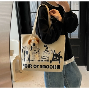 Detail of canvas tote bag featuring minimalist pet prints and a plush puppy charm