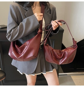 Detail of burgundy crescent shoulder bags with knot handle in two sizes on model