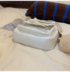 Dettaglio borsa a tracolla in tela bianca con finestra in PVC e ciondolo di peluche