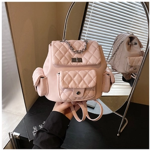 Detail view of light pink quilted mini backpack with silver metal chain and twist lock