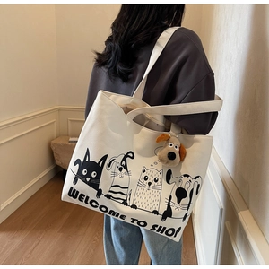 Large cream canvas tote bag with pet illustrations and puppy pendant shown on model