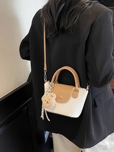 Retro cream crossbody bucket bag with brown handles and a cute teddy bear charm