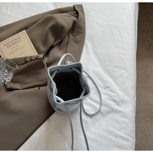 Vue de dessus du sac seau en cuir bleu clair montrant l'intérieur et le cordon de serrage