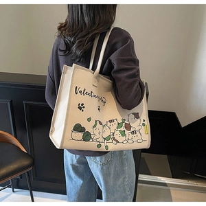 Detailansicht der cremeweißen Canvas-Tragetasche mit Cartoon-Katzen und Herz-Motiven