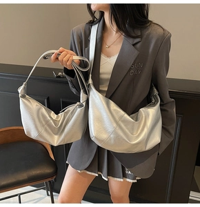 Detailed view of silver metallic crescent hobo bags with decorative knot strap design