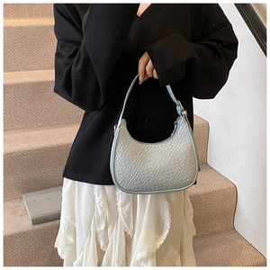 Detailed view of light blue crescent bag featuring crocodile embossed leather texture