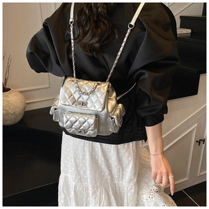 Silver quilted backpack featuring metallic faux leather and elegant chain straps