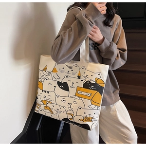 Detail shot of canvas tote bag featuring an all-over cartoon cat pattern and large capacity