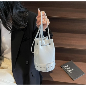 Détail du sac seau bleu clair avec œillets métalliques argentés et sangle à boucle décorative