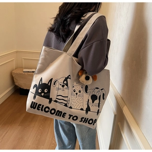 Canvas tote bag detail showing cartoon pet print and cute plush puppy keychain accessory