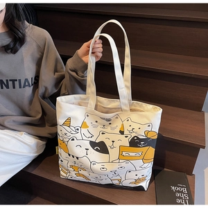 Detail of cartoon cat print canvas tote bag on stairs with minimalist aesthetic style