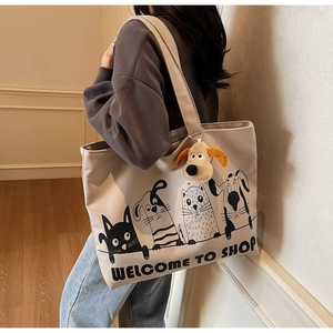 Spacious beige canvas tote bag with cartoon print and plush dog charm on shoulder