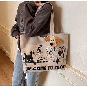 Detail of canvas tote bag featuring cute cartoon animal prints and a plush puppy charm