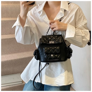 Fashionable black quilted mini backpack with silver metal buckle on female model