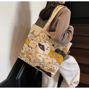 Detail of cartoon cat pattern on large canvas tote bag with wide shoulder strap