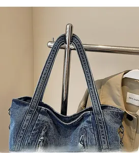 Detail of durable denim shoulder strap and metal zipper on vintage blue tote bag