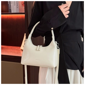 Detail of minimalist cream leather crescent shoulder bag with silver zipper and logo