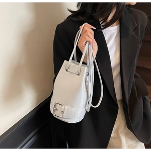 Détail du sac seau blanc avec cordon de serrage et ceinture décorative en bas