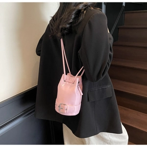 Sac seau rose avec cordon de serrage, boucle décorative et détails zippés latéraux