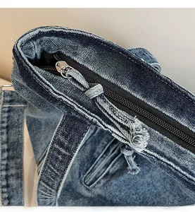 Macro detail of the durable denim bag showing smooth zipper and reinforced stitching