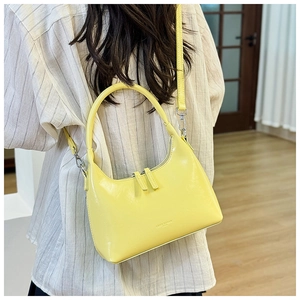 Detail of bright yellow leather hobo bag with dual zipper closure and detachable strap