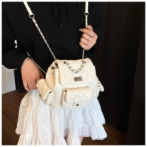 Detailed view of the quilted texture and chain strap on a white mini backpack