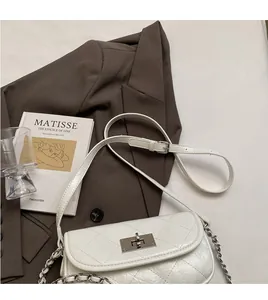 Detail of white quilted mini chain bag with silver twist lock and leather straps