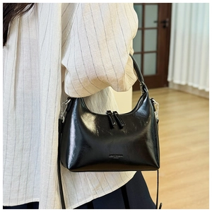 Polished black crescent shoulder bag with silver hardware and adjustable strap detail