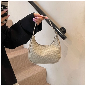 Close-up of champagne crescent bag featuring crocodile pattern and metallic texture