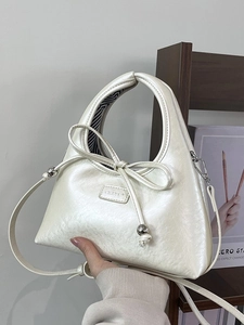 Minimalist pearl white underarm crescent bag with bow detail and silver accents