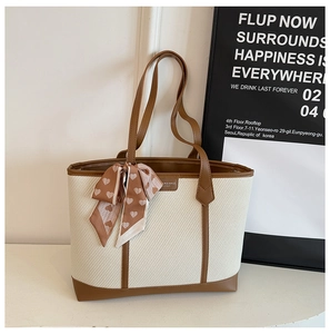 Détail du sac cabas tissé crème avec garniture en cuir synthétique marron et foulard en soie