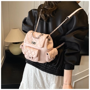 Pink quilted leather mini backpack with silver chain straps shown on a model