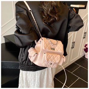 Detailed back view of a pink quilted mini backpack with chain strap on a model