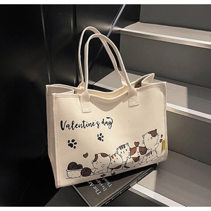 Detail der weißen Canvas-Tasche mit Cartoon-Katzen-Print und stabilen Doppelgriffen