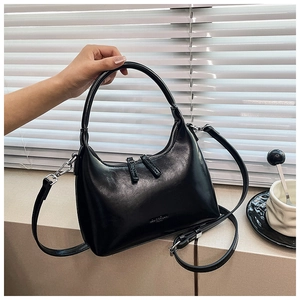 Detail of black crescent hobo bag with smooth leather texture and adjustable strap