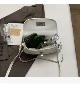 Detailed interior of a white quilted chain bag showing space for phones and cosmetics