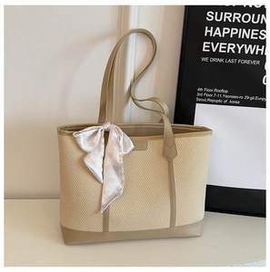 Détail du grand sac cabas avec texture tissu, bordure cuir kaki et accent écharpe en soie