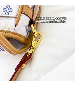 Detail of the golden metal hook and colorful clover pattern on the white luxury bag