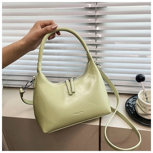 Detail of light green crescent bag showing the smooth PU leather texture and hand strap