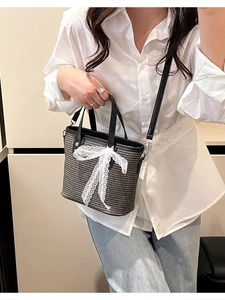 Handmade woven tote bag with lace bow and black leather straps for beach vacations