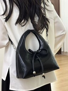 Minimalist black matte crescent underarm bag with bow detail and silver metal beads