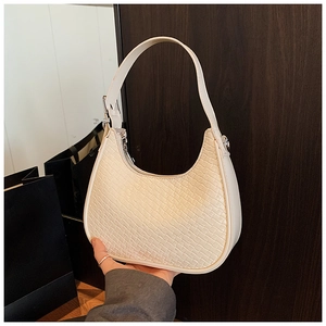 Detailed close-up of woven texture and silver buckle on off-white hobo shoulder bag