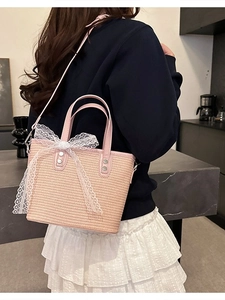 Pink straw woven handbag with white lace bow and adjustable shoulder strap for summer vacation