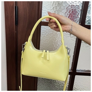 Detailed view of yellow crescent armpit bag with smooth leather finish and double zippers